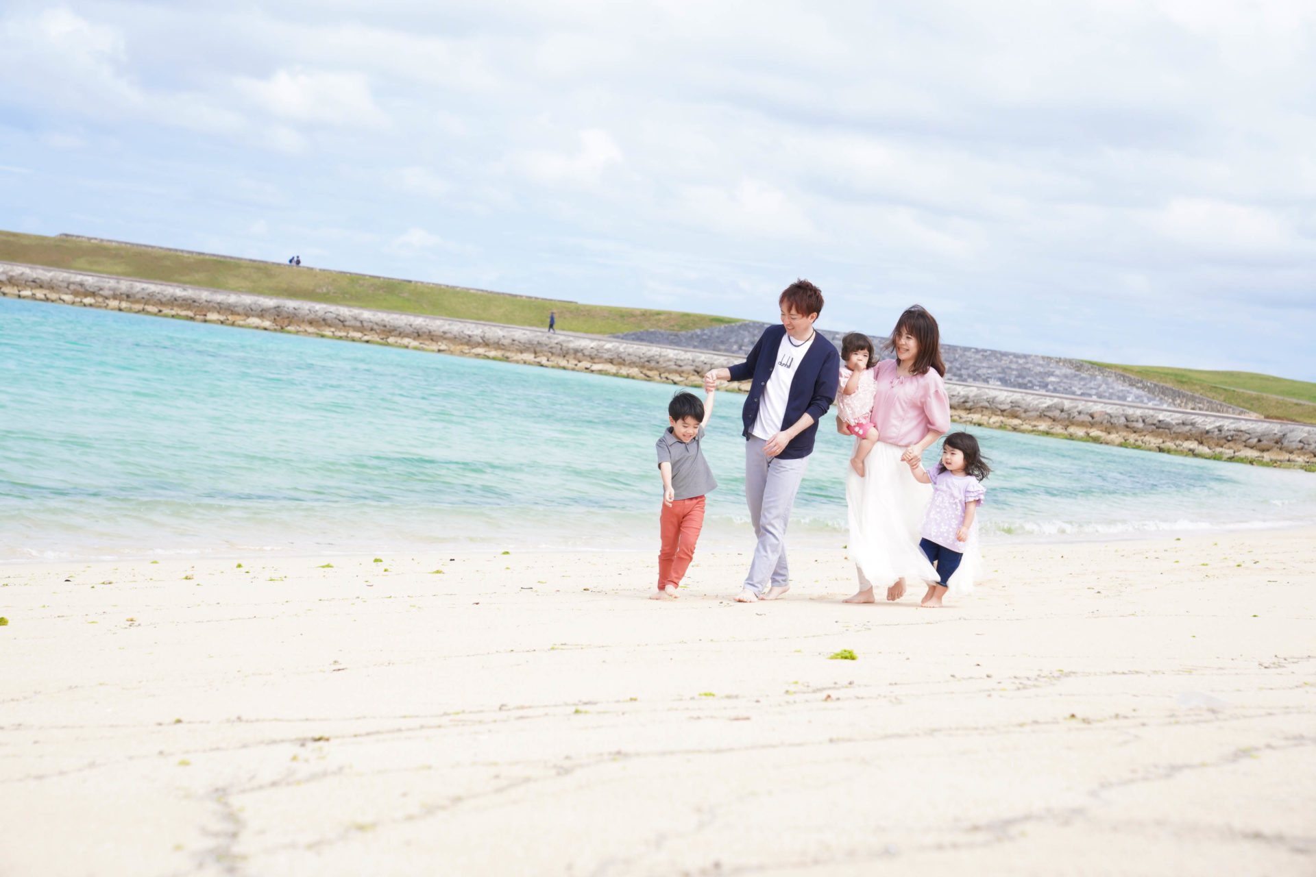 スカイブルーの海を背景に、パパ、ママ、お子様3人で仲良くお散歩中